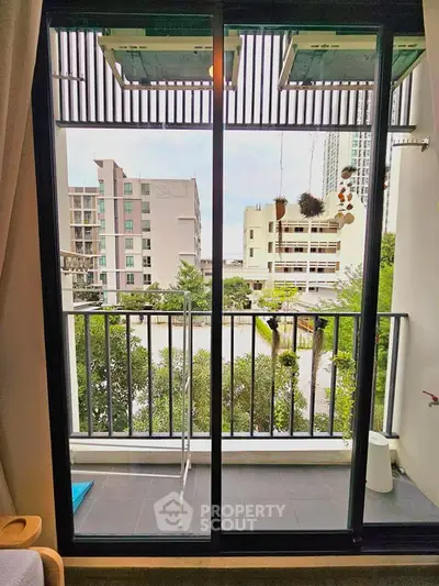 Charming balcony view with urban landscape and greenery, perfect for relaxation.