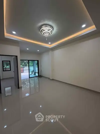 Spacious modern living room with elegant ceiling lighting and large sliding glass doors.