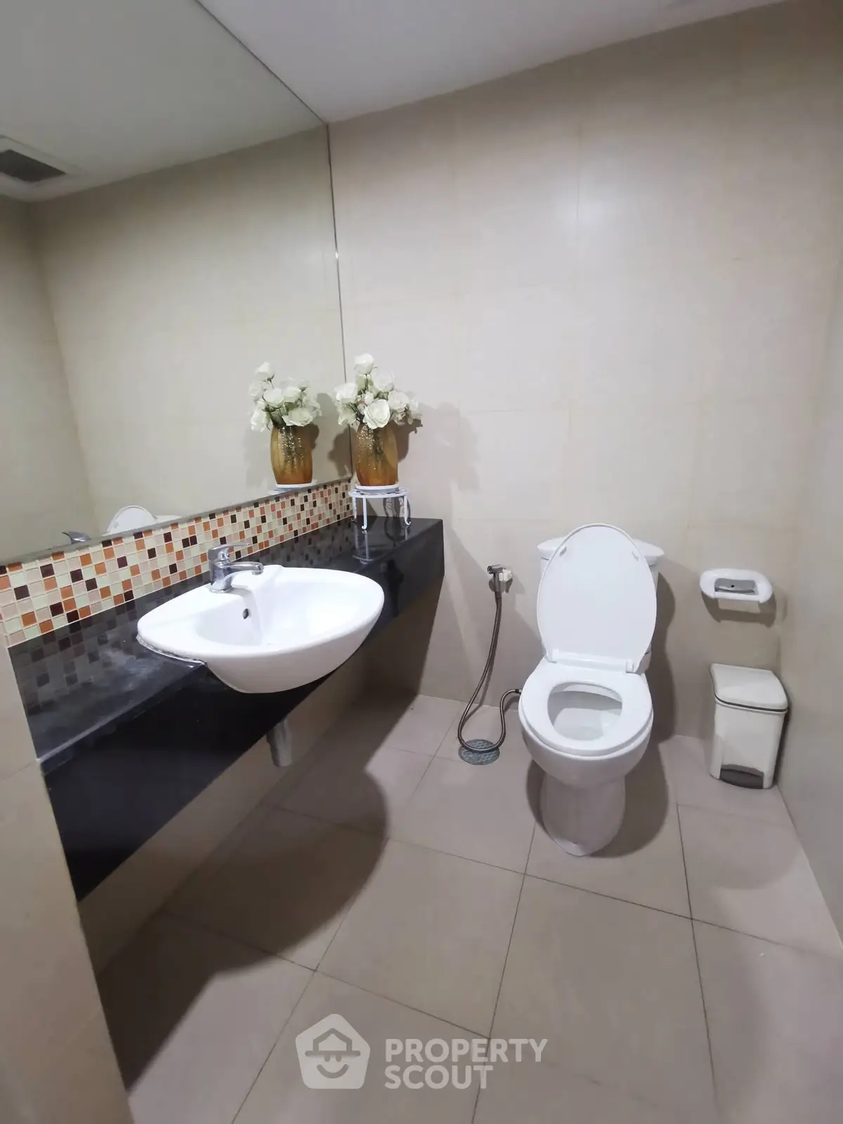 Modern bathroom with elegant sink and toilet, featuring stylish floral decor.