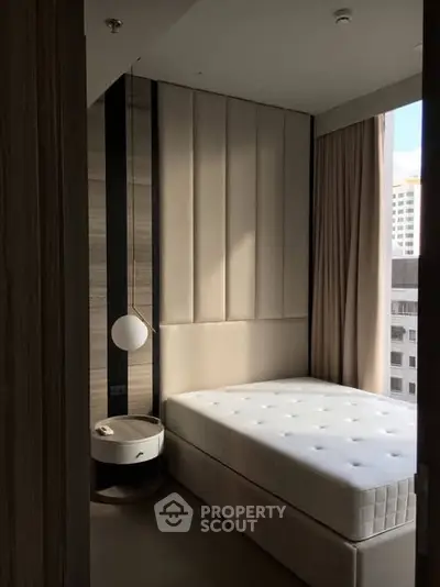 Modern bedroom with stylish decor and city view, featuring a cozy bed and elegant lighting.