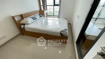 Modern bedroom with large window and city view, featuring a comfortable bed and sleek tiled flooring.