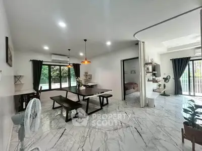 Spacious open-plan living and dining area with marble flooring and modern decor.