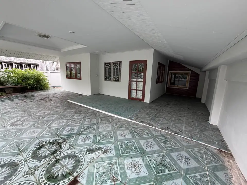 Spacious covered patio with decorative tile flooring and garden view