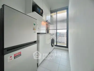 Modern kitchen with appliances and balcony view in sleek apartment