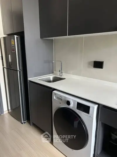 Modern kitchen with sleek cabinetry and built-in washing machine