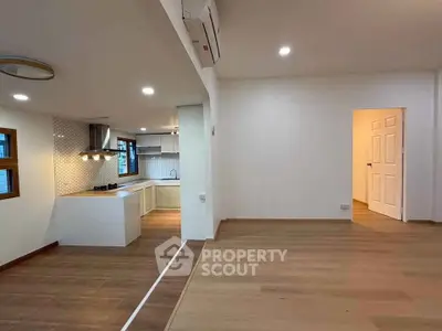 Spacious open-plan living room with modern kitchen and wooden flooring