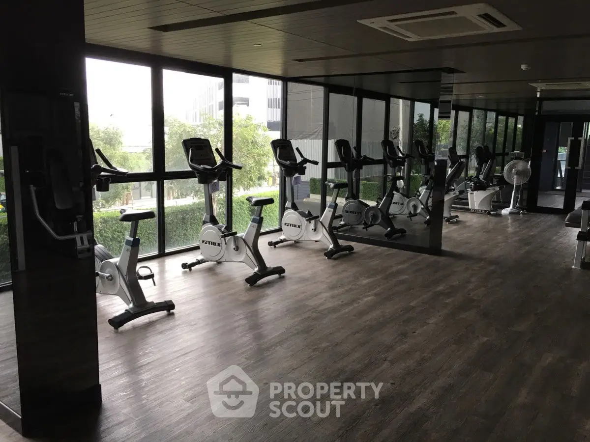 Modern gym with exercise bikes and large windows offering a scenic view.