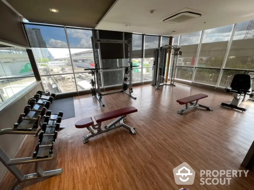 Modern gym with large windows and fitness equipment in a high-rise building