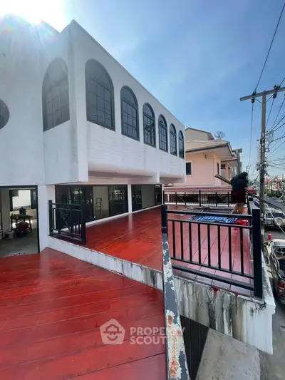 Spacious balcony with modern railing and city view in a contemporary building.