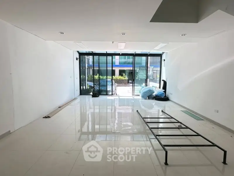 Spacious modern living room with large windows and glossy white tiles