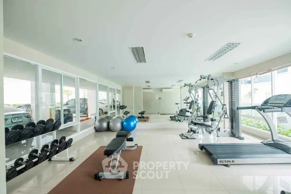 Spacious modern gym with state-of-the-art equipment and natural lighting.