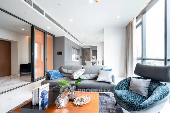 Luxurious modern living room with floor-to-ceiling windows and stylish furniture in a high-rise apartment.
