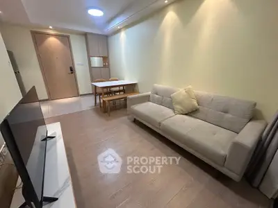 Modern living room with cozy sofa and dining area in open layout apartment.