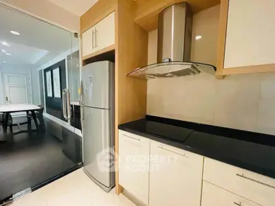 Modern kitchen with sleek appliances and glass door leading to dining area