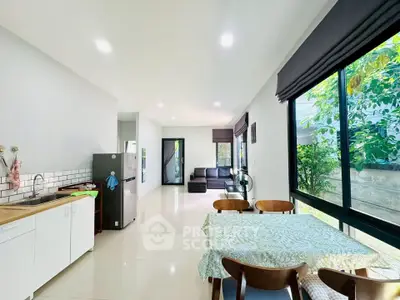 Spacious open-plan living and dining area with modern kitchen and large windows.