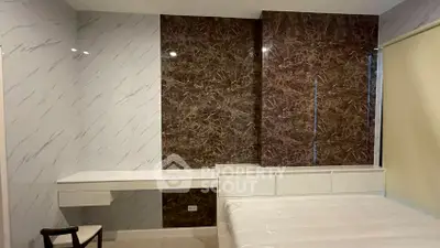 Modern bedroom with elegant marble accent wall and sleek furniture design