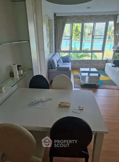 Modern living room with large windows and stylish furniture, offering a bright and inviting atmosphere.