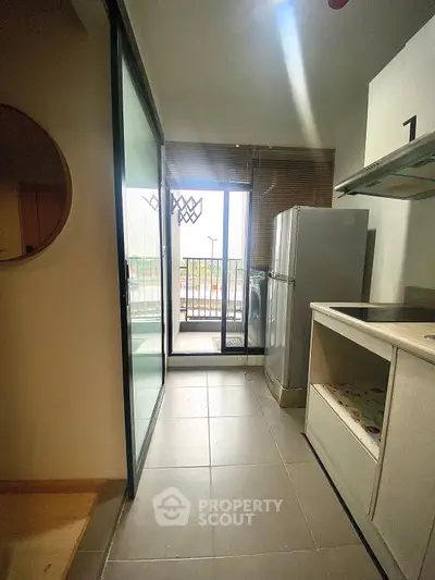 Modern kitchen with balcony access and sleek appliances in urban apartment