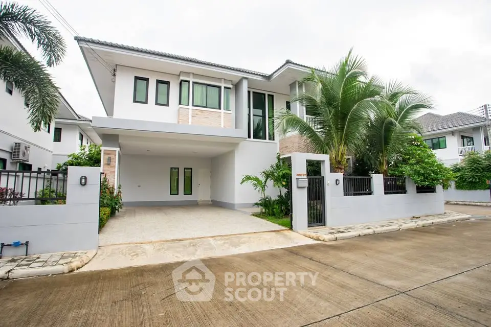 Modern two-story house with spacious driveway and lush greenery in a serene neighborhood.