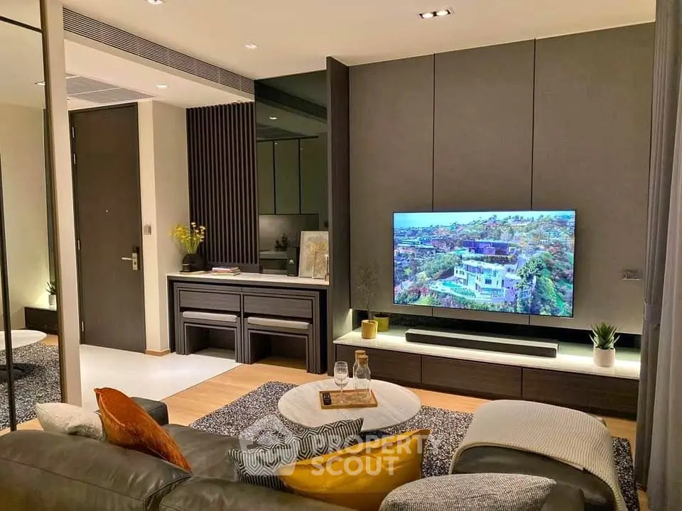 Modern living room with stylish decor and large TV, perfect for relaxation and entertainment.