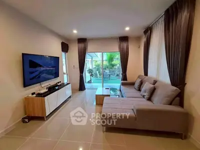 Modern living room with sleek furniture and large windows overlooking a lush garden.