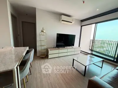 Modern living room with large TV, air conditioning, and balcony view in stylish apartment.