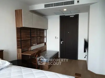 Modern bedroom with stylish wood furniture and wall-mounted TV in a sleek apartment.