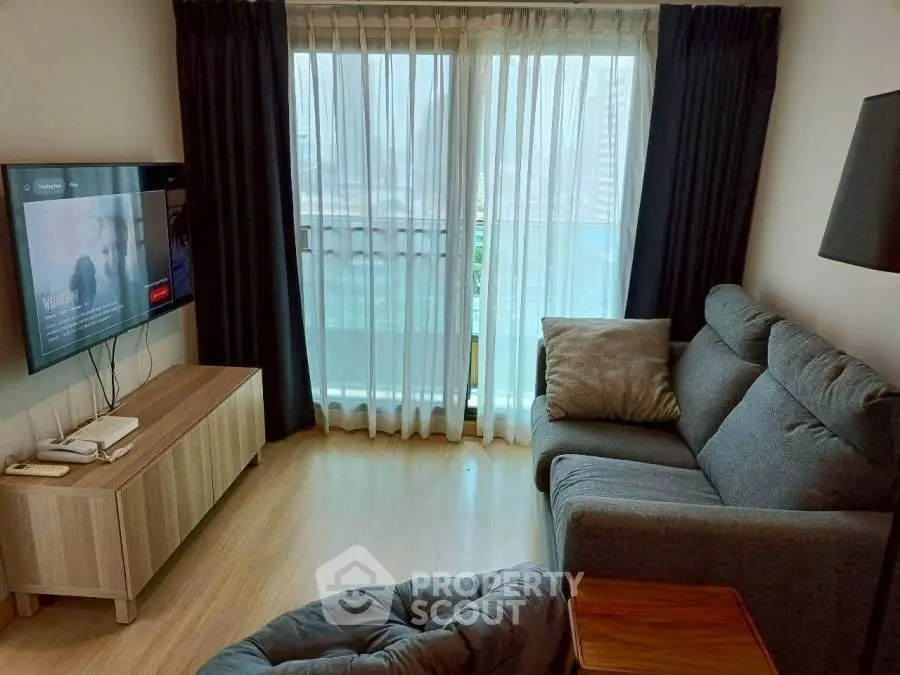 Cozy living room with modern furniture and large window offering natural light.