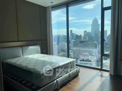 Luxurious bedroom with stunning city view and modern furnishings in high-rise apartment.