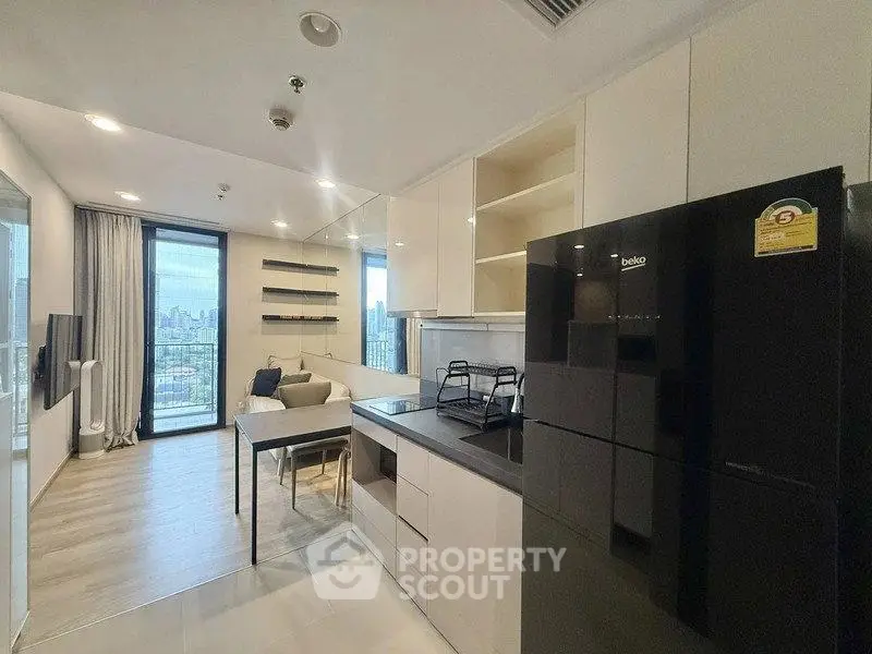 Modern open-layout kitchen and living room with city view in a stylish apartment.