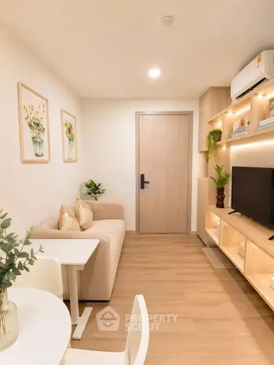 Cozy modern living room with stylish decor and wooden flooring, featuring a comfortable sofa and wall-mounted TV.