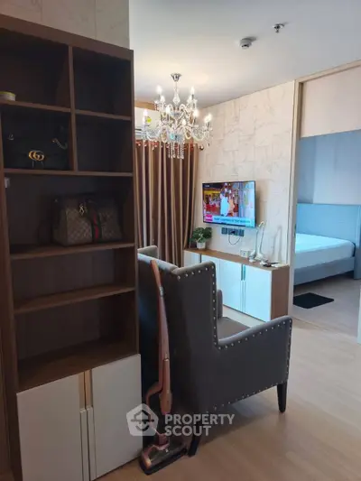 Stylish modern living room with chandelier and open view to bedroom