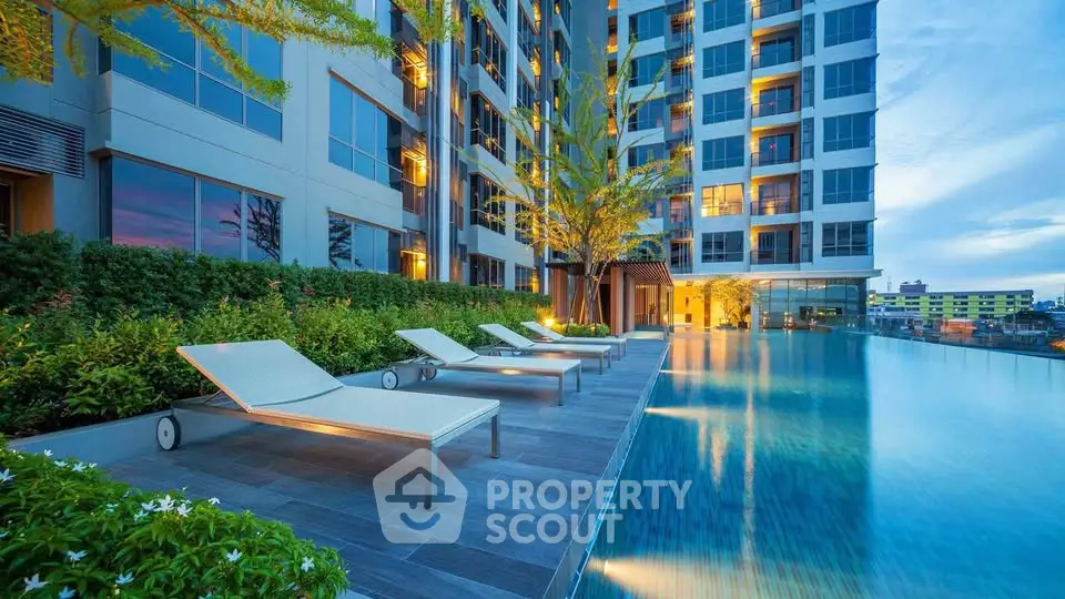 Luxurious apartment building with stunning poolside view at sunset.