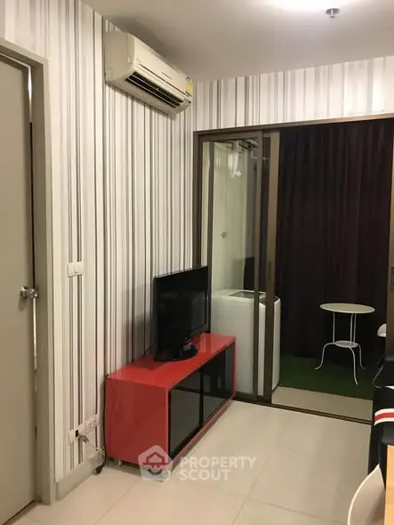 Modern living room with air conditioning and small balcony access.