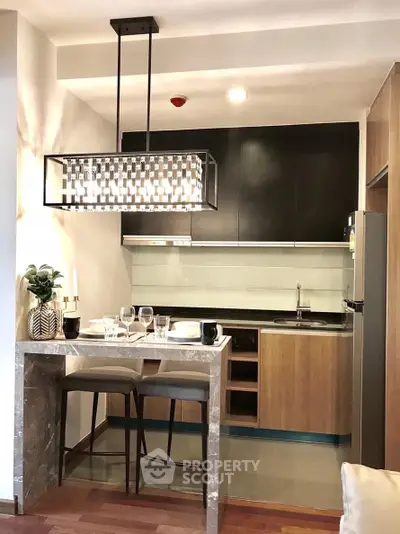 Modern kitchen with sleek design and stylish lighting in a contemporary apartment.