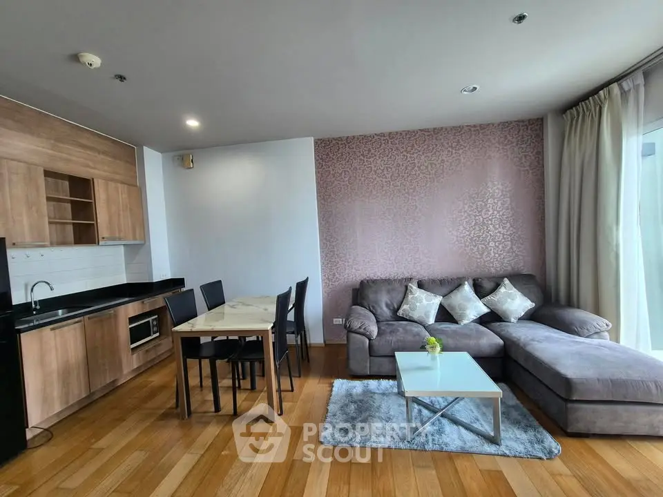 Modern living room with open kitchen, featuring a cozy sectional sofa and dining area, perfect for urban living.