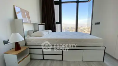 Modern bedroom with large window offering stunning city view, featuring sleek furniture and neutral tones.