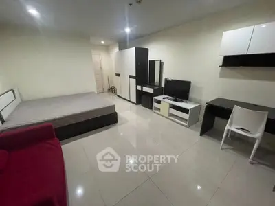 Spacious studio apartment with modern furnishings and tiled flooring, ideal for urban living.
