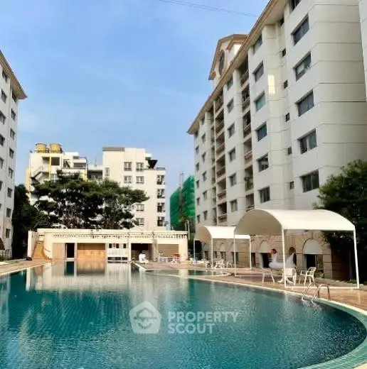 Luxurious apartment complex with a stunning outdoor pool and modern architecture.