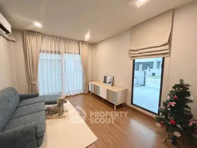 Modern living room with stylish decor, wooden flooring, and large windows for natural light.