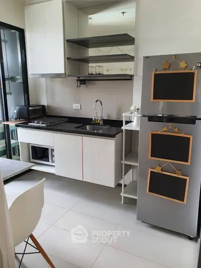 Modern kitchen with sleek cabinetry and stainless steel appliances in compact layout.