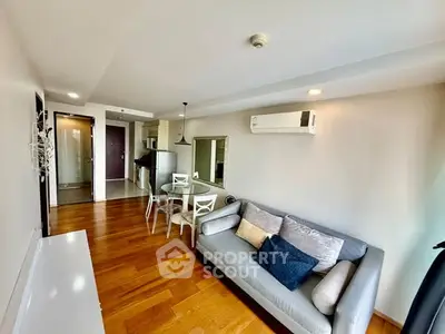 Modern living room with wooden flooring and stylish furniture in a cozy apartment.