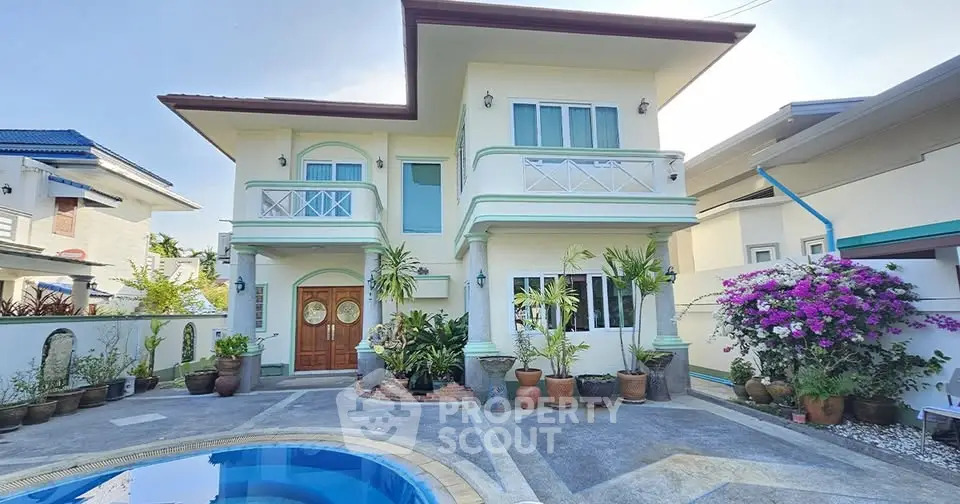 Stunning two-story house with pool and lush garden, perfect for luxurious living.
