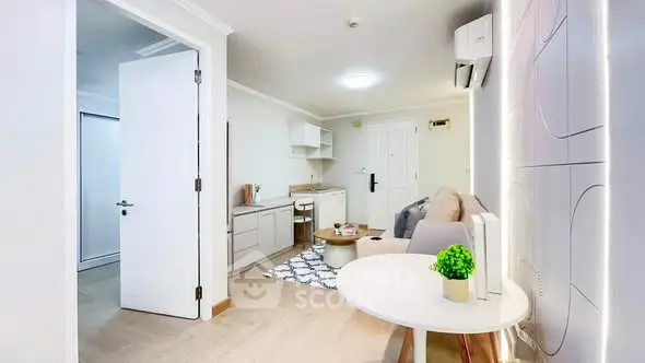 Modern living room with stylish decor and open layout, featuring a cozy seating area and sleek kitchenette.