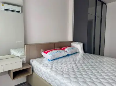 Modern bedroom with sleek design and ample storage space, featuring a comfortable bed and air conditioning.