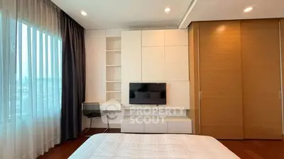 Modern bedroom with built-in storage, wall-mounted TV, and large window with city view.
