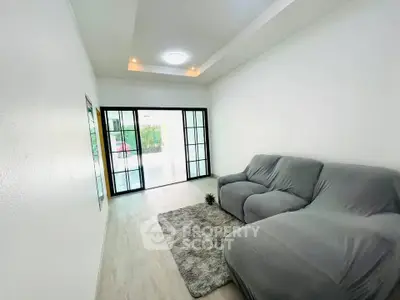 Spacious living room with modern decor and large glass doors leading to a patio.