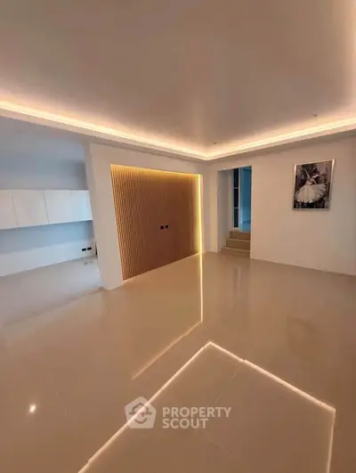 Modern minimalist living room with sleek lighting and glossy tiled floors