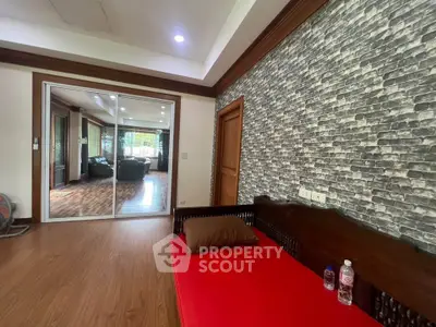 Spacious living area with stylish brick accent wall and cozy seating, perfect for relaxation.