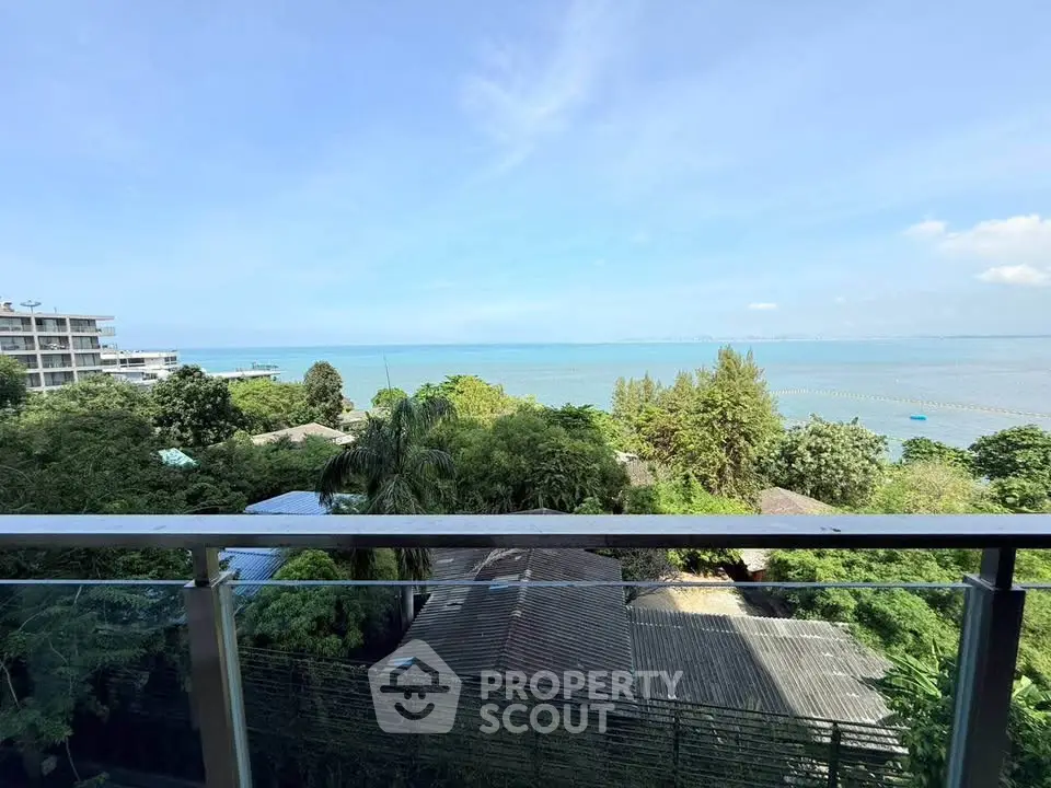 Stunning ocean view from a balcony with lush greenery and clear blue skies.